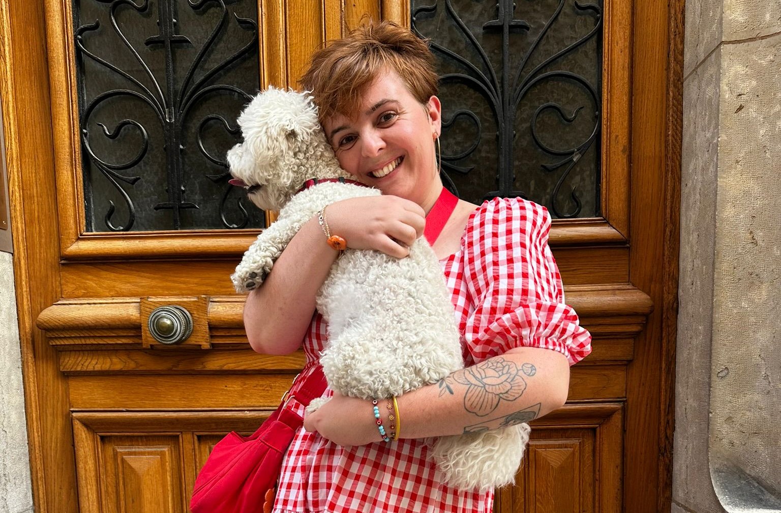 camille avec son chien mochi se font un calin dans la rue devant une porte.