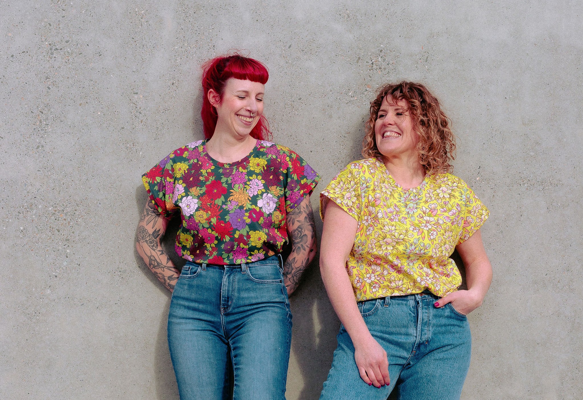 Julie et Loren rigolent ensemble adossées à un mur